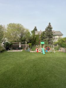 Gyermekjátszótér csúszdával, játékokkal, hintával és homokozóval